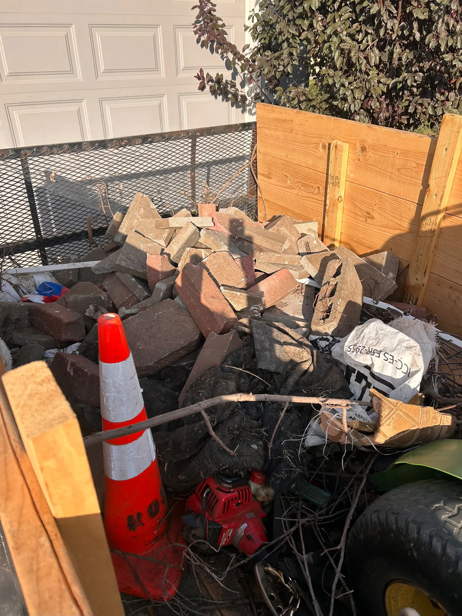 Trailer loaded with broken masonry, branches, and mixed debris for removal